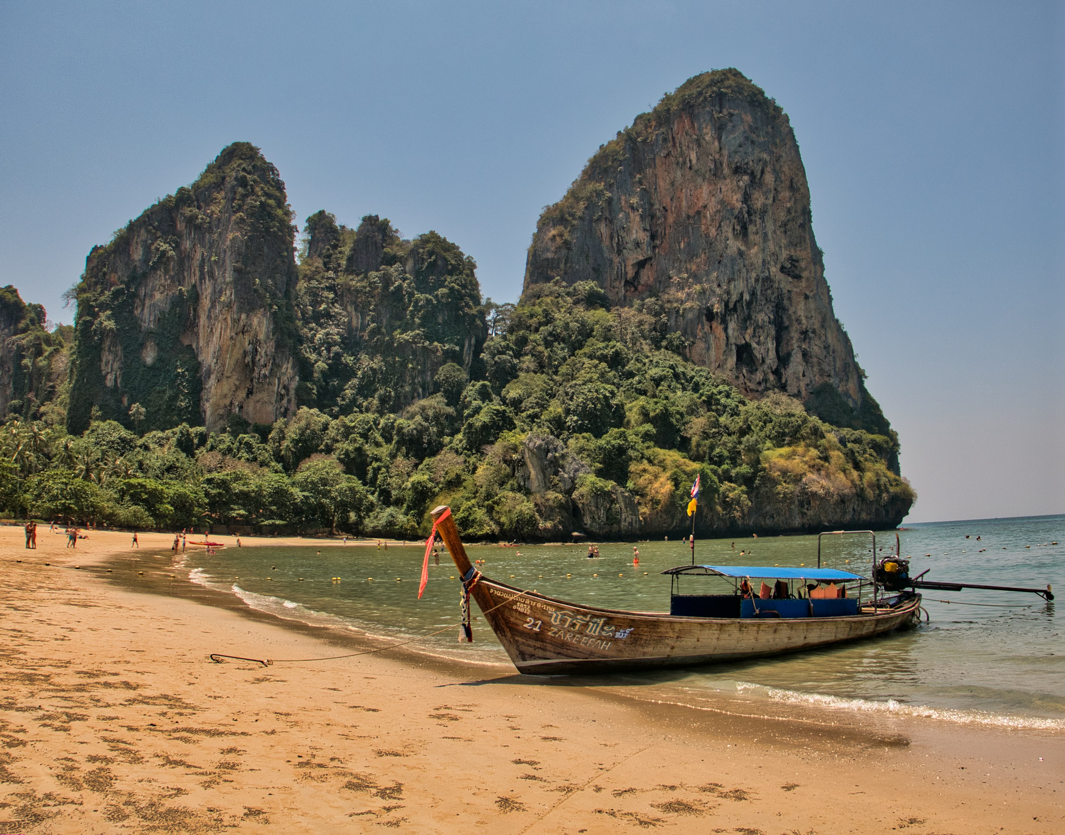 A boat on the beach with mountains in the background